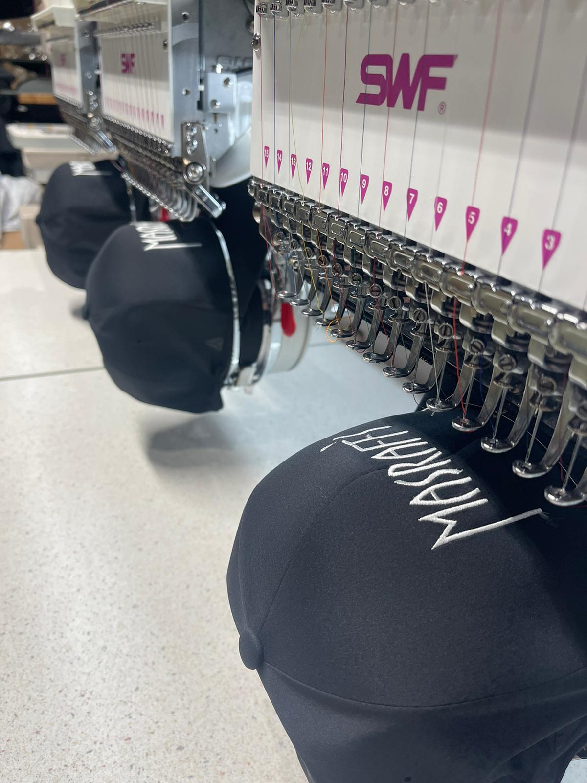 Embroidery machine working on Brooklyn caps